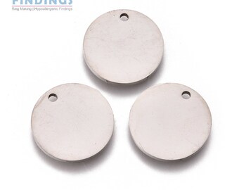 May include: Three silver round metal discs with a small hole at the top. The discs are blank and can be used for jewelry making.