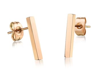 May include: A pair of rose gold bar stud earrings. The earrings are simple and minimalist, with a straight bar design.