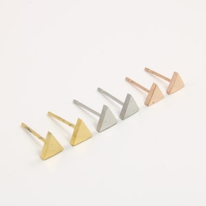 May include: Set of three triangle stud earrings in gold, silver and rose gold.