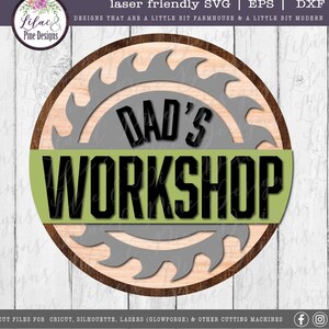 May include: A round wooden sign with a saw blade design and the text "DAD'S WORKSHOP" in black letters on a green background.
