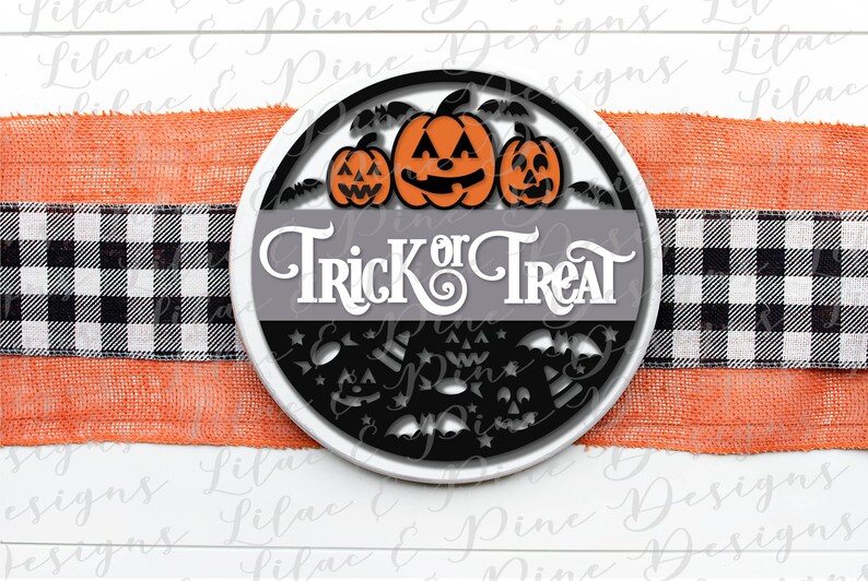 K&ouml;nnte beinhalten: Ein rundes, schwarz-wei&szlig;es Schild mit dem Text "Trick or Treat" in wei&szlig;en Buchstaben. Drei orangefarbene K&uuml;rbisse mit schwarzen Augen und M&uuml;ndern befinden sich &uuml;ber dem Text. Das Schild ist von schwarzen Flederm&auml;usen und Sternen umgeben.