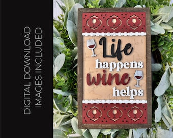 May include: Wooden framed sign with the phrase "Life happens wine helps". The sign has a red and white decorative border with wine glass cutouts. The words "Life" and "helps" are in black and white, while "wine" is in red.