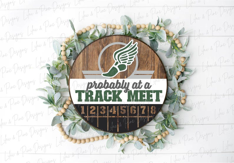 May include: A round wooden sign with a track and field theme. The sign features a green and white winged shoe graphic and the text "probably at a TRACK MEET". Numbers 1-8 are displayed below.