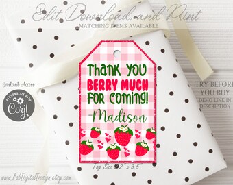 May include: A rectangular gift tag with a pink and white gingham pattern, featuring red strawberry illustrations, small red hearts, and the green and red text: Thank you BERRY MUCH FOR COMING! -Madison. The tag includes a hole at the top.