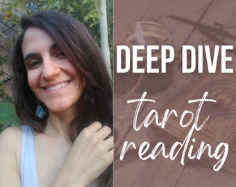 May include: A woman smiles at the camera while holding a strand of her long brown hair. The background is a blurred image of green foliage. The text "DEEP DIVE tarot reading" is superimposed on a brown wooden background.