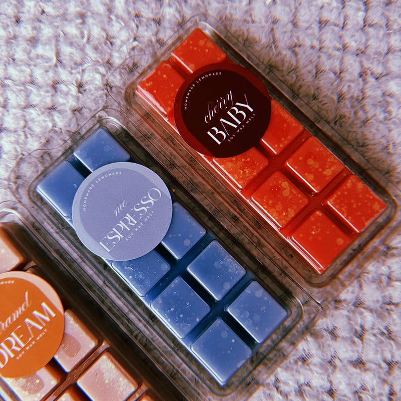 May include: Three wax melts in clear plastic containers. The wax melts are in the scents "The Espresso", "Cherry Baby", and "Caramel Dream".
