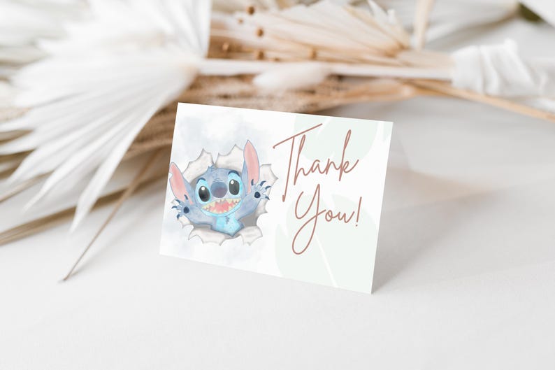 May include: A blue and white cartoon character, Stitch, peeks out of a hole in a white background. The text "Thank You!" is written in brown cursive on a green background.