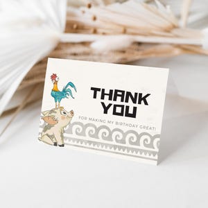 May include: A white card with the text "THANK YOU" in black, with the phrase "FOR MAKING MY BIRTHDAY GREAT!" below. The card features illustrations of a rooster and a pig. A decorative wave pattern is at the bottom.