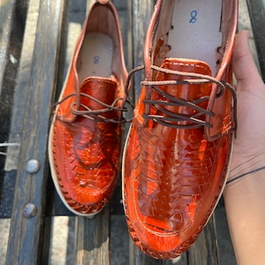 May include: A pair of brown leather shoes with a woven design. The shoes have laces and are size 8.