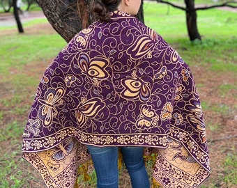 May include: A purple and gold shawl with a floral and butterfly pattern. The shawl has tassels on the edges.