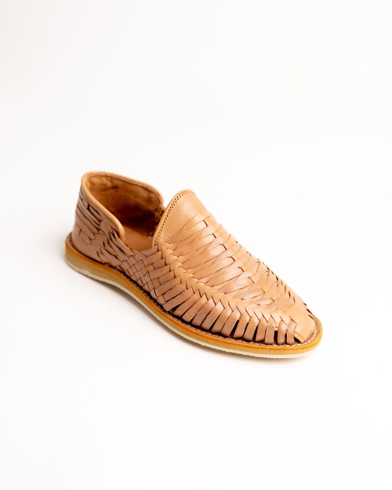 May include: A tan leather woven loafer shoe. The shoe features a slip-on design with a woven upper and a light-colored sole. The shoe is made of leather and has a classic, casual style.