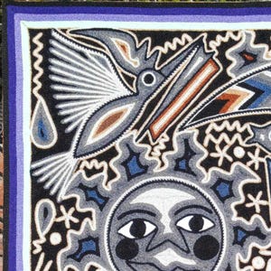 May include: A rectangular textile wall hanging featuring a central sun face with human-like features, surrounded by a flying bird and abstract geometric patterns. The design uses a palette of black, white, blue, and brown yarn on a dark background.