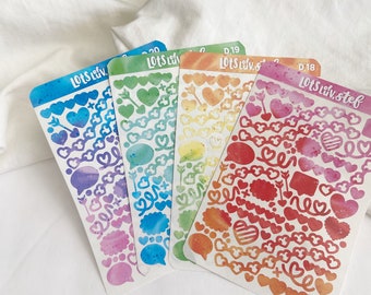 Puede incluir: Cuatro hojas de pegatinas de colores arcoíris con varias formas de corazón, burbujas de diálogo y flechas. Las pegatinas están etiquetadas como "Lots of Luv" y tienen un efecto acuarela.