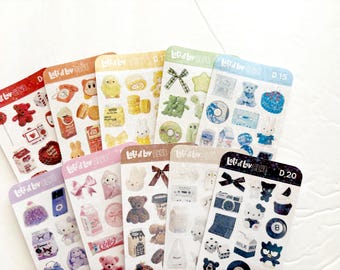 Puede incluir: Varias hojas de pegatinas coloridas con diversos diseños, incluyendo osos de peluche, lazos y alimentos. Cada hoja tiene el texto "Lots of Luv Club" y presenta un diseño único.