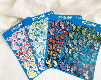 Puede incluir: Tres hojas de pegatinas de mariposas de colores con el texto "LotS Liv.stef" y un número en cada hoja. Las pegatinas están sobre un fondo azul.