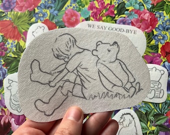May include: A collection of Winnie the Pooh-themed patches. The main patch features a sketch of Pooh and Christopher Robin. Other patches show Pooh in various poses. One patch has the text "WE SAY GOOD-BYE". The patches are on a floral background.