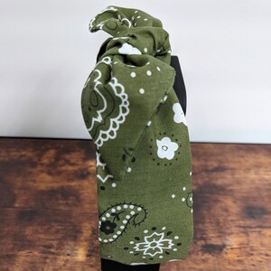 May include: Green headband with a white and black paisley pattern.