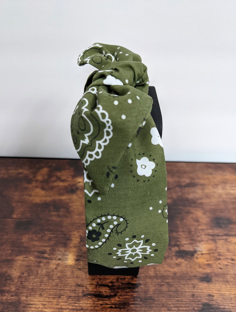 May include: Green headband with a white and black paisley pattern.