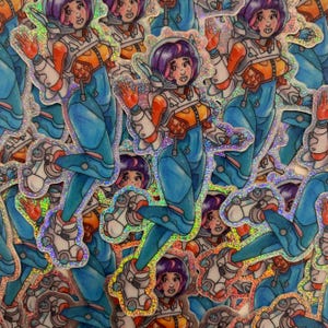 May include: A collection of holographic stickers featuring a cartoon character wearing a blue and white spacesuit with orange accents. The character has purple hair and is waving.