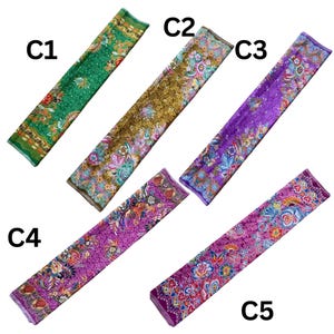 May include: Five rectangular fabric strips labeled C1 through C5, each featuring intricate floral and paisley patterns. C1 is green, C2 is gold and teal, C3 is purple and blue, C4 is magenta and pink, and C5 is deep purple with vibrant floral motifs.