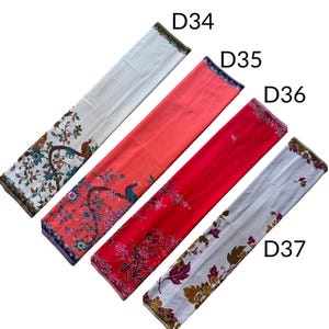 May include: Four rectangular fabric pieces labeled D34, D35, D36, and D37. D34 is white with a peacock and floral print. D35 is coral with a peacock and floral print. D36 is red with a floral print. D37 is white with a brown and purple floral print.