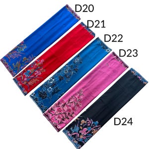 May include: Five rectangular fabric pieces labeled D20 through D24, featuring floral patterns. D20 is blue, D21 is red, D22 is teal, D23 is pink, and D24 is black. Each piece displays intricate botanical designs with varied color accents.
