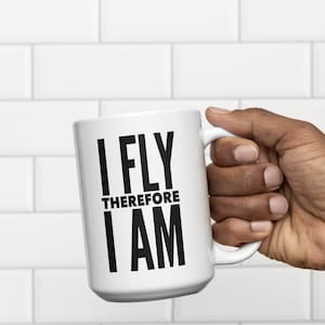 May include: White ceramic mug with black text that reads "I FLY THEREFORE I AM".