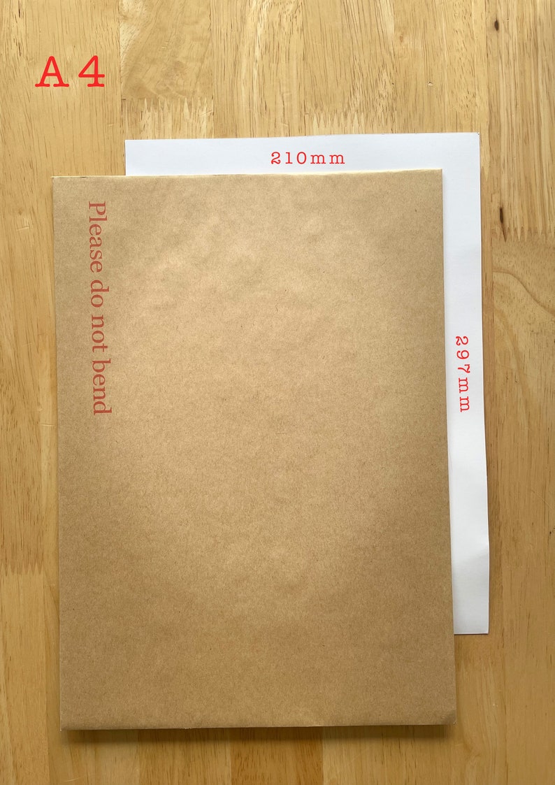 Puede incluir: Un sobre de papel marr&oacute;n con el texto "Please do not bend" impreso en la parte delantera. El sobre mide 210 mm de ancho y 297 mm de largo. El sobre est&aacute; sobre una superficie de madera.