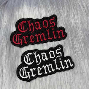 May include: Two embroidered patches with black backgrounds and scalloped edges. The top patch features the text Chaos Gremlin in red gothic-style lettering. The bottom patch features the same text in white gothic-style lettering.