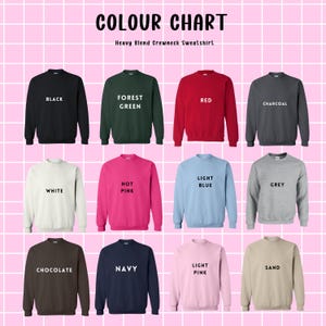 May include: Color chart showing 12 different colors of heavy blend crewneck sweatshirts. The colors are: black, forest green, red, charcoal, white, hot pink, light blue, grey, chocolate, navy, light pink, and sand.