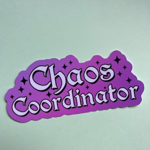 May include: Purple and white sticker with the text "Chaos Coordinator" in a stylized font with stars around the text.