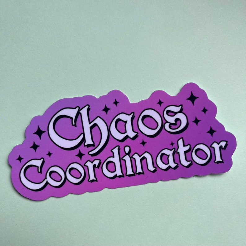 May include: Purple and white sticker with the text "Chaos Coordinator" in a stylized font with stars around the text.