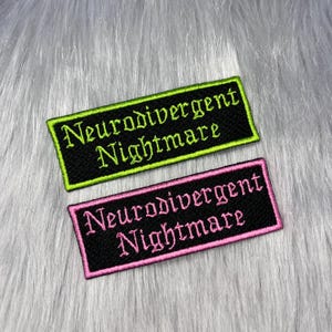 Puede incluir: Dos parches rectangulares bordados con fondo de tela negra. El parche superior presenta texto en verde lima que dice Neurodivergent Nightmare con un borde verde a juego. El parche inferior presenta texto en rosa que dice Neurodivergent Nightmare con un borde rosa a juego.