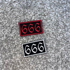 May include: Two embroidered patches with the number 666. The top patch is black with red stitching and the bottom patch is white with black stitching.