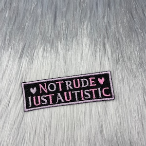 Peut inclure: Patch brodé noir et blanc avec des cœurs roses et le texte "NOT RUDE JUST AUTISTIC".