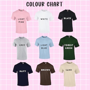 May include: Color chart showing nine different t-shirt colors: light pink, white, black, grey, light blue, forest green, navy, brown, and sand.