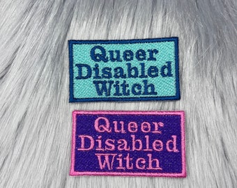 May include: Two embroidered patches with the text "Queer Disabled Witch" in different colors. The top patch is teal with navy blue lettering. The bottom patch is purple with pink lettering.