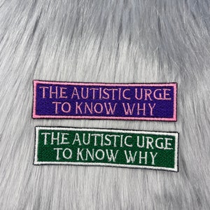 Puede incluir: Dos parches bordados con el texto "The autistic urge to know why". El parche superior es morado con letras rosas y el parche inferior es verde con letras blancas.