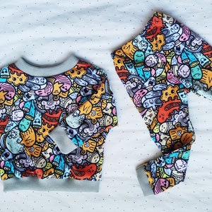 Puede incluir: Un juego de tres tazas de cerámica con un acabado moteado y mate. Las tazas son de color crema, gris claro y gris oscuro. Cada taza tiene un diseño simple y moderno y un asa redondeada.