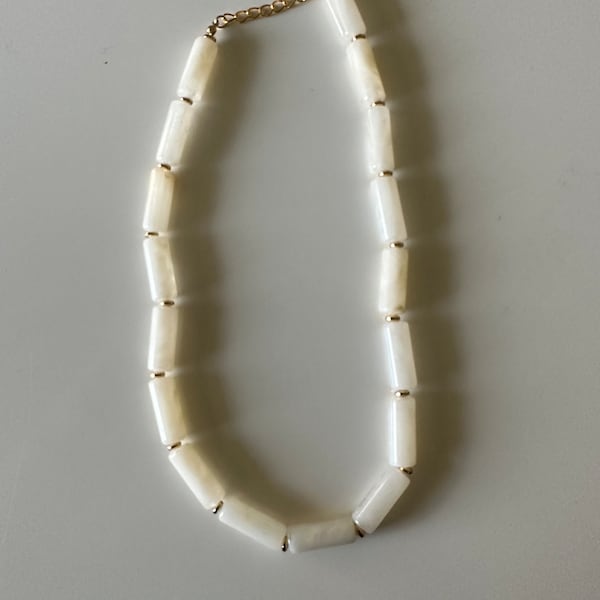 Collier en acrylique nacré blanc et perles tubes dorées. pieceuvre d'art fabriquée et finie à la main, sophistiquée, accrocheuse et réglable.