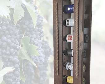 May include: A rustic wooden wine rack with rope accents. The rack is designed to hold six bottles of wine. The rack is made of reclaimed wood and has a natural finish.