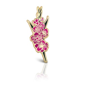 May include: Gold-toned enamel pin featuring a pink gladiolus flower with green leaves.