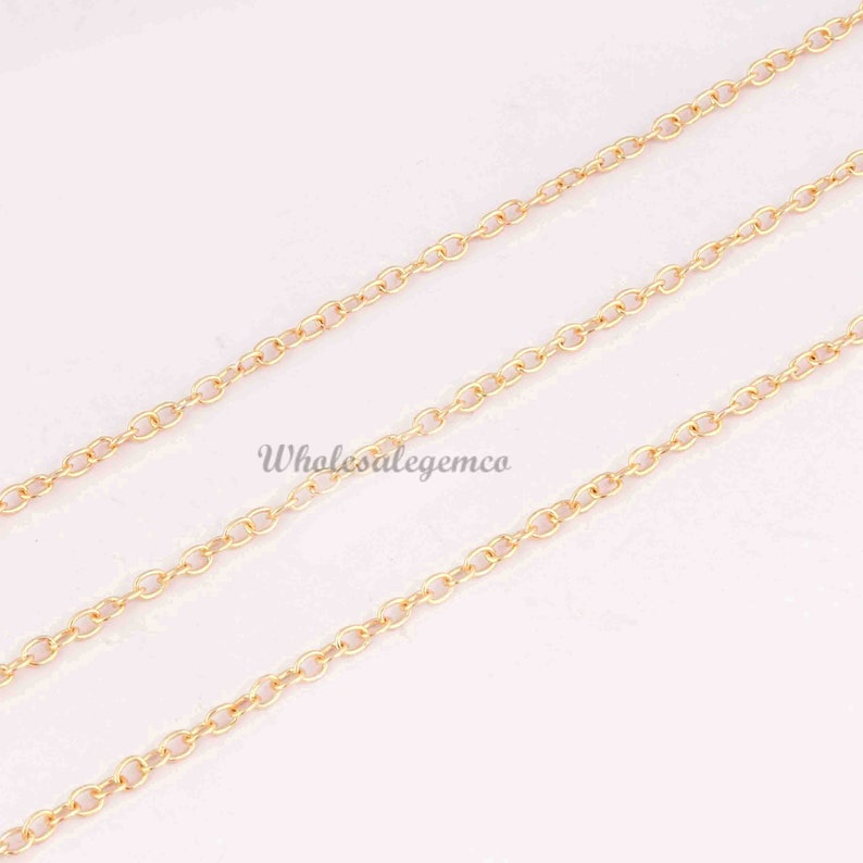 May include: A gold-colored metal chain featuring a series of small, uniform oval links connected in a continuous strand. The text Wholesalegemco is printed in a dark font across the center of the chain segments, which are arranged diagonally.