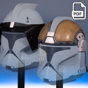 Op de afbeelding: Twee gedetailleerde clone trooper helmen, lichtblauw en grijs, een met een zwart vizier en de andere met een bruin en grijs bovenstuk. De helmen worden gepresenteerd tegen een blauwe gradiënt achtergrond. Een PDF-pictogram staat rechtsboven.