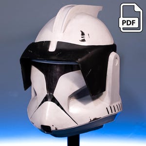 May include: A white and black helmet with a visor, likely for cosplay or costume use. The helmet has a distinctive design with a black visor and accents. The PDF icon in the corner suggests a digital download.