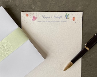 May include: White envelope with a green and white label that says "Tell Your Story". The envelope is next to a white sheet of stationery with a butterfly design and the text "Maryjane & Knightlight, Honey Farm, Belvoir, Leicestershire, AL1 8SD".