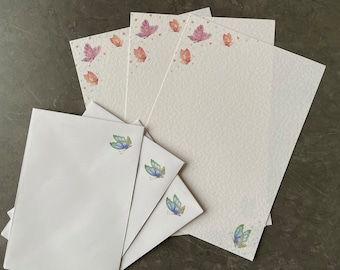May include: Set of white stationery paper with a delicate butterfly design. The paper features a subtle watercolor effect and is perfect for writing letters or notes.