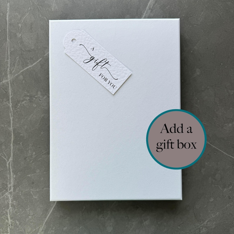 May include: White gift box with a tag that says "A gift for you". The box has a teal circle with the text "Add a gift box" on it.