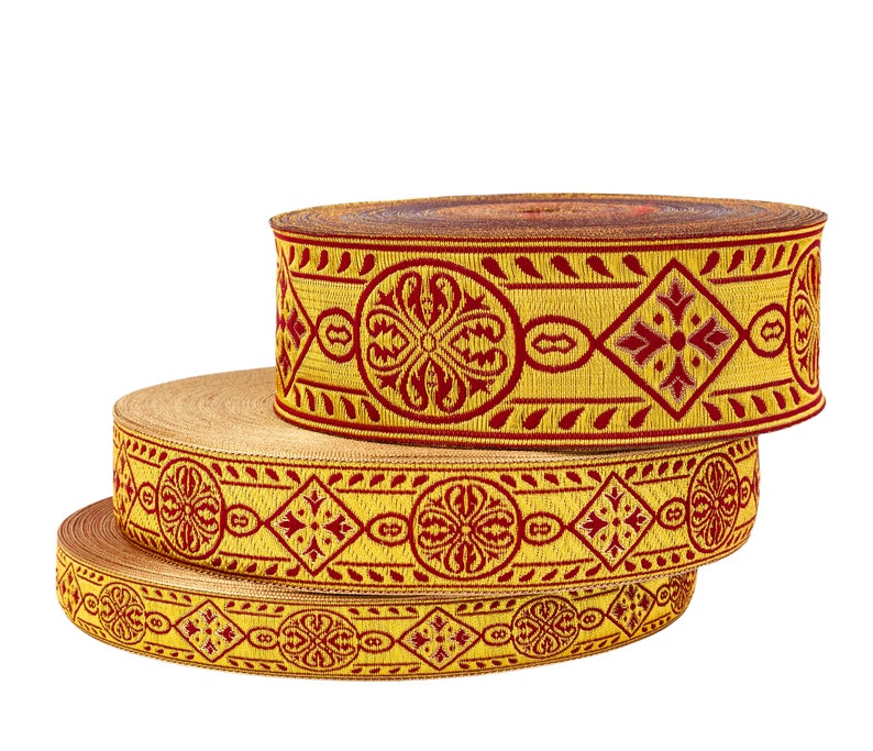 May include: Three rolls of gold and red patterned trim with intricate designs. The trim is woven with a repeating pattern of flowers and geometric shapes.