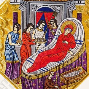 Puede incluir: Un icono bordado que representa la Natividad de Jesús. La escena muestra a María acostada en una cama con una manta roja, mientras que el bebé Jesús está en un pesebre. Hay tres mujeres de pie alrededor de la cama, una sosteniendo una cesta de comida.